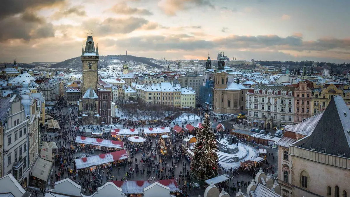 Lit Old Town Bridge Tower and Charles Bridge at dusk in Prague in winter