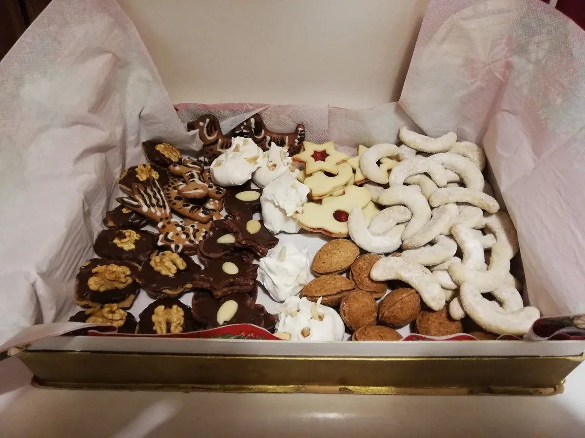 Box of assorted Czech Christmas cookies including vanilla crescents and chocolate cukroví
