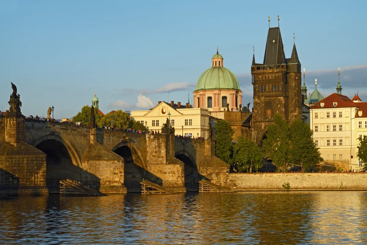 Old Town Bridge Tower at the end of Charles Bridge in golden evening light across the Vltava