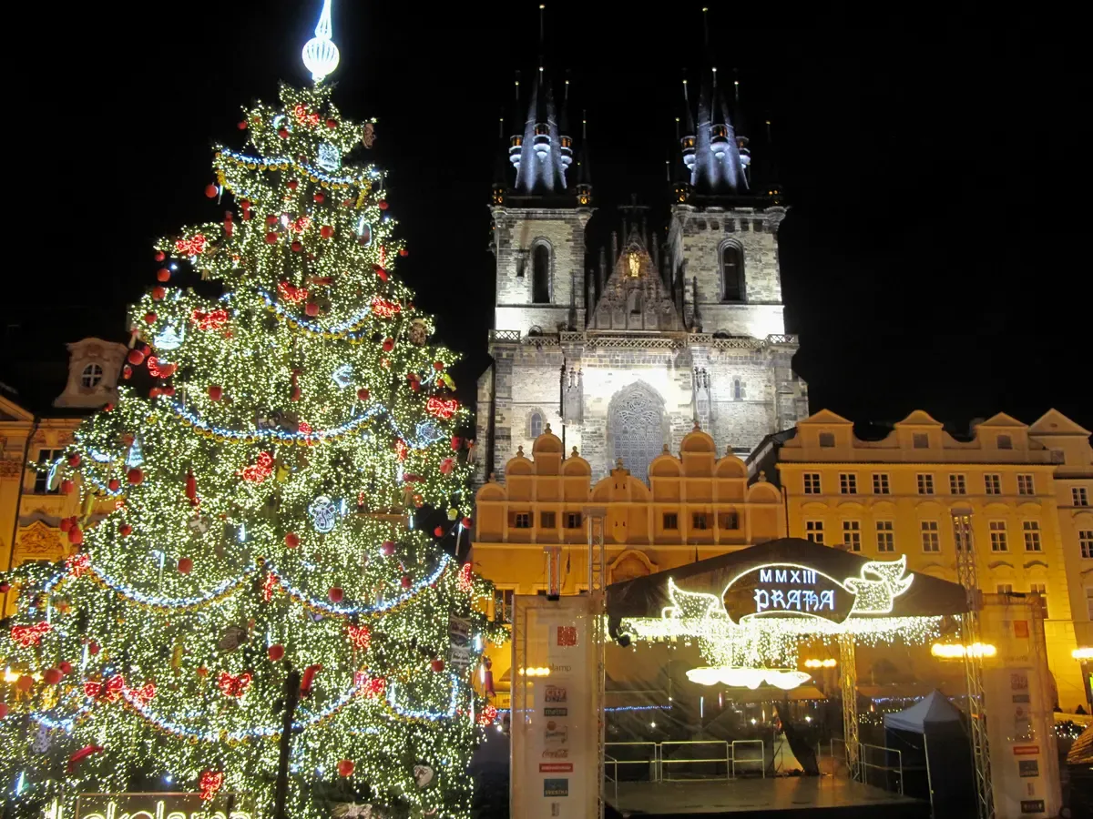 Old Town Square Christmas tree lit in front of the Týn Church at night